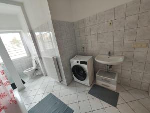 a bathroom with a washing machine and a sink at Revant West 2 in Arnstadt