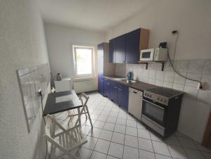 a kitchen with blue cabinets and a table and a stove at Revant West 2 in Arnstadt