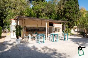a group of blue tables and chairs in front of a building at Hotiday Otranto Porto in Otranto