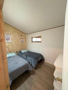 a bedroom with two beds and a window at Parcela Peumayen Casa 4 in Pucura