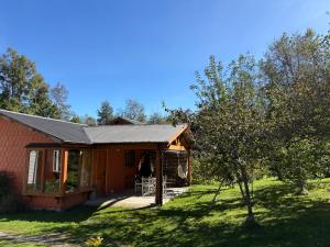 a small house with a porch and a tree at Parcela Peumayen Casa 4 in Pucura