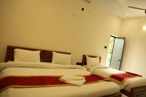 two beds sitting next to each other in a bedroom at Lumiere Point Yercaud in Yercaud