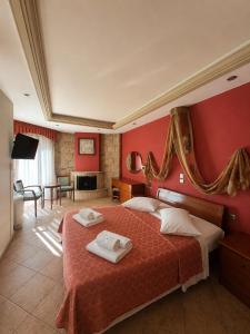 ein Schlafzimmer mit roten Wänden und einem Bett mit zwei Handtüchern. in der Unterkunft Giannis & Foteini in Afytos + 76 Fotos