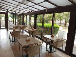 a restaurant with tables and chairs and windows at Pingvin Panzió in Komárom