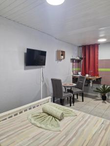 a living room with a tv and a table and chairs at Cayenne MIRZA 2 Confort T2 in Cayenne