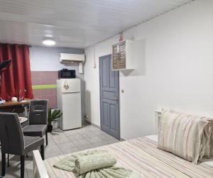 a room with a kitchen with a table and a refrigerator at Cayenne MIRZA 2 Confort T2 in Cayenne +24 photos
