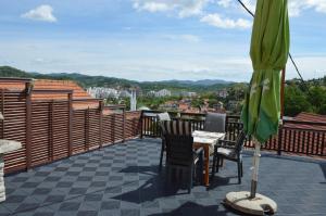 a patio with a table and chairs and an umbrella at Apartments Mensa in Tuzla