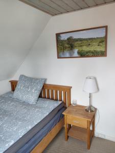 a bedroom with a bed and a table with a lamp at Like home Holiday House 9 A in Varde