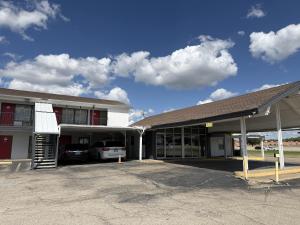 a building with a car parked in a parking lot at Thunderbird Motel Hillsboro in Hillsboro