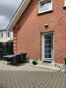 a patio with a table and chairs in front of a brick building at Like home Holiday House 9 A in Varde