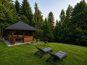 a gazebo with a picnic table and chairs in a yard at Biały Domek Świerczek - Jacuzzi, Balia Ruska SPA, Rowery, Altana i Grill w Słopnice in Słopnice +39 photos