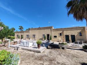 a building with tables and chairs in front of it at Masseria Don Egidio in Melendugno