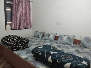 a bed with pillows on it in a bedroom at Punchkedar in Phata
