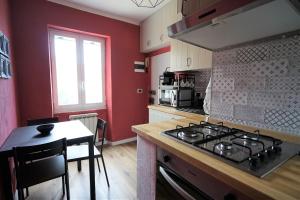 a kitchen with a stove and a table and a kitchen with red walls at Venus and the Sea in Fezzano