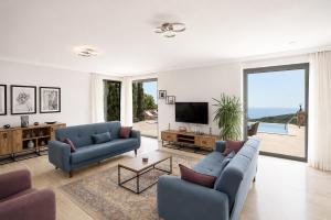 a living room with two blue couches and a television at Villa Emilie in Kaş