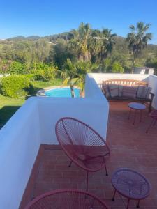 a patio with tables and chairs next to a pool at Authentic Villa with amazing pool in Santa Gertrudis de Fruitera