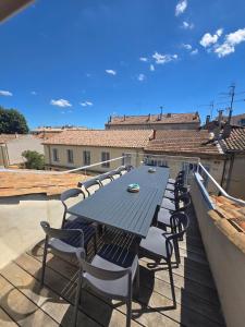 a table and chairs sitting on a roof at Cocon des Arènes Nîmes Centre 18 couchages in Nîmes