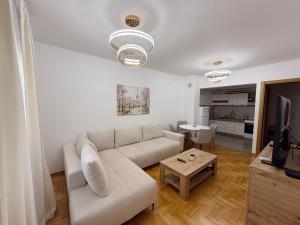 a living room with a couch and a table at Sky & Sea View Apartment Budva in Budva