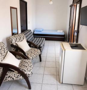 a living room with two chairs and a couch at Hotel D'Italia in Arroio do Sal