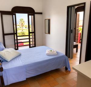 a bedroom with a bed and a door to a patio at Hotel D'Italia in Arroio do Sal
