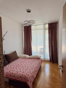 a bedroom with a bed and a large window at Sky & Sea View Apartment Budva in Budva