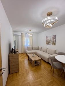 a living room with a couch and a table at Sky & Sea View Apartment Budva in Budva
