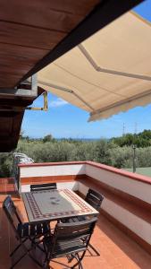 a patio table and chairs under a large umbrella at MAREMONTI alloggio turistico in Formia