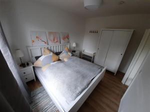 a bedroom with a white bed with pillows at Rikes Ferienwohnung 2 in Heinsberg