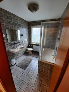 a bathroom with a shower and a tub and a sink at Rikes Ferienwohnung 2 in Heinsberg +3 photos
