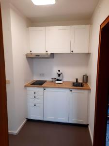 a kitchen with white cabinets and a counter top at Rikes Ferienwohnung 2 in Heinsberg