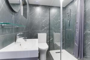 a bathroom with a toilet and a sink and a shower at Katolondonhaus in Mitcham +20 photos