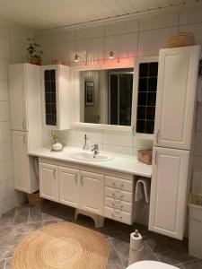 a white bathroom with a sink and a mirror at Yttermoveien in Narvik +18 photos