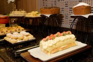 a table topped with a slice of cake and other desserts at Locanda Hotel in Novo Hamburgo