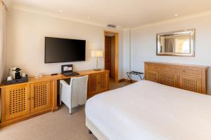 a bedroom with a bed and a flat screen tv at Best Western Premier Montfleuri in Sainte-Maxime