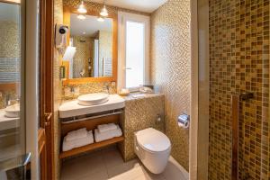 a bathroom with a toilet and a sink and a mirror at Best Western Premier Montfleuri in Sainte-Maxime