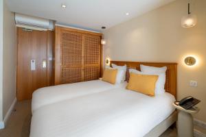 a bedroom with a large white bed and a telephone at Best Western Premier Montfleuri in Sainte-Maxime +87 photos