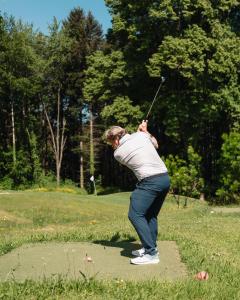 a man swinging a golf club in a park at Domaine de Dolomieu Hotel & Spa - BW Premier Collection in Dolomieux +140 photos