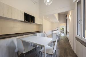 a kitchen with a white table and chairs at Vettori Hideaway by MMega in Florence