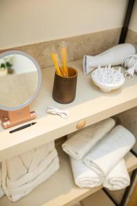 a bathroom shelf with a mirror and towels at Kö102 Prime Suites in Düsseldorf