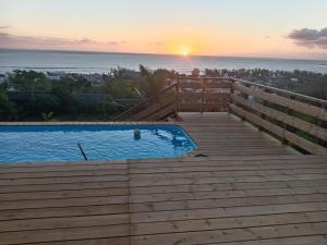 a swimming pool with the sunset in the background at Les Vavangues in Saint-Leu