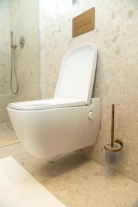 a white toilet in a bathroom with a shower at Kö102 Prime Suites in Düsseldorf