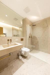 a bathroom with a sink and a toilet at Kö102 Prime Suites in Düsseldorf