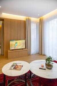 a living room with two tables and a flat screen tv at Kö102 Prime Suites in Düsseldorf +62 photos
