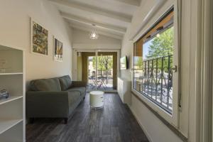 a living room with a couch and a balcony at Vettori Hideaway by MMega in Florence