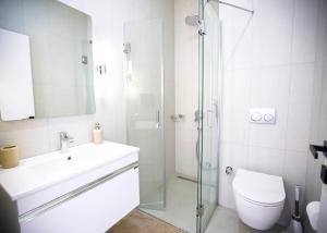 a bathroom with a shower and a sink and a toilet at Aqualina C2-4 by HolidayKeys in Kyrenia +20 photos