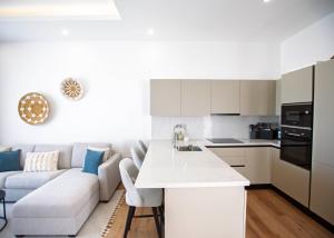 a kitchen and living room with a couch and a table at Aqualina C2-4 by HolidayKeys in Kyrenia