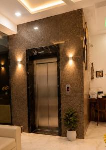 a elevator in a lobby with a plant next to it at Hotel Boston Rooms by SOT - Affordable Stay near Taj #Parking #Ac #2 min drive to Taj in Agra