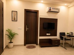 an office lobby with a door and a tv at Hotel Boston Rooms by SOT - Affordable Stay near Taj #Parking #Ac #2 min drive to Taj in Agra +17 photos
