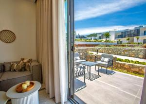 a room with a balcony with a couch and chairs at Aqualina B3-2 by HolidayKeys in Kyrenia