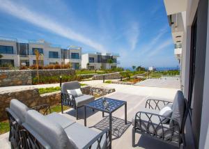 a patio with chairs and a table on a balcony at Aqualina B3-2 by HolidayKeys in Kyrenia